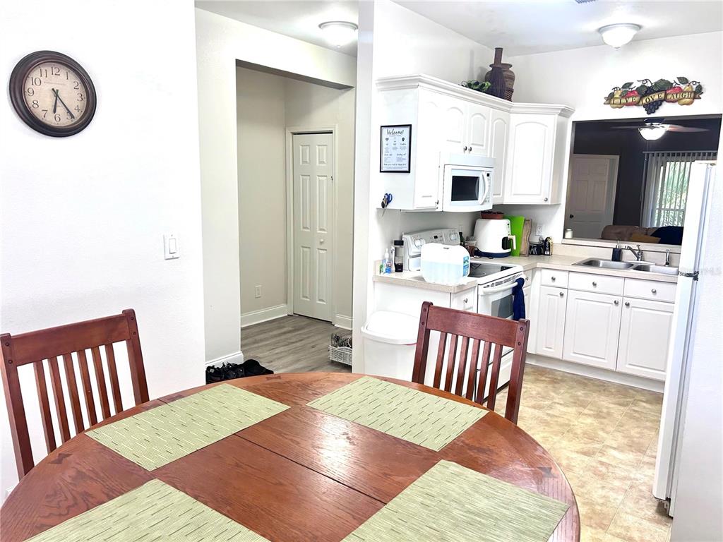 A brown front door with a keypad lock is situated next to a window with blinds — 8842 CORAL PALMS COURT UNIT B, KISSIMMEE, FL
