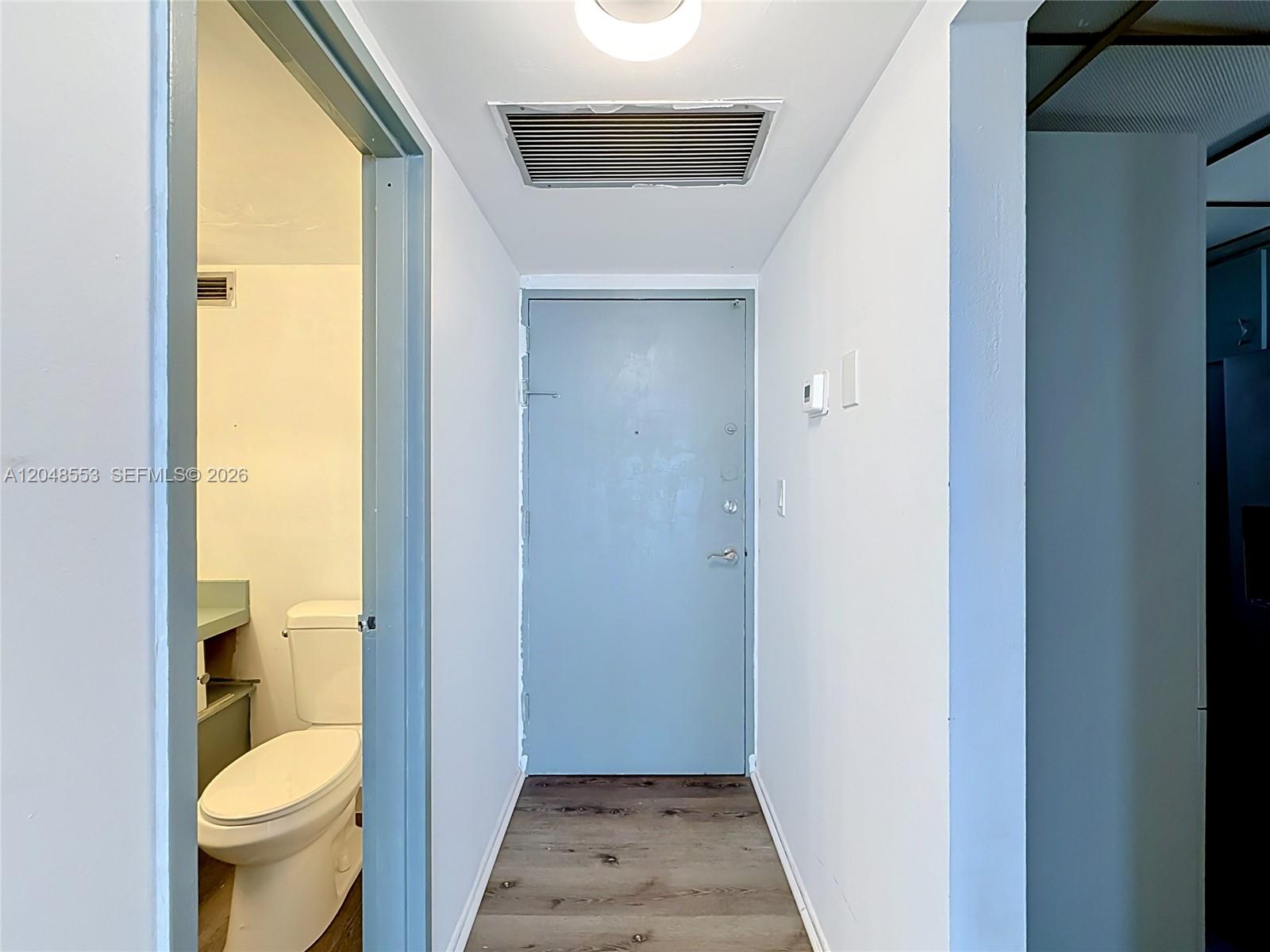 A hallway leads to a gray entry door, with a bathroom visible on the left — 1228 West Ave # 208, Miami Beach FL 33139, MIAMI BEACH, FL