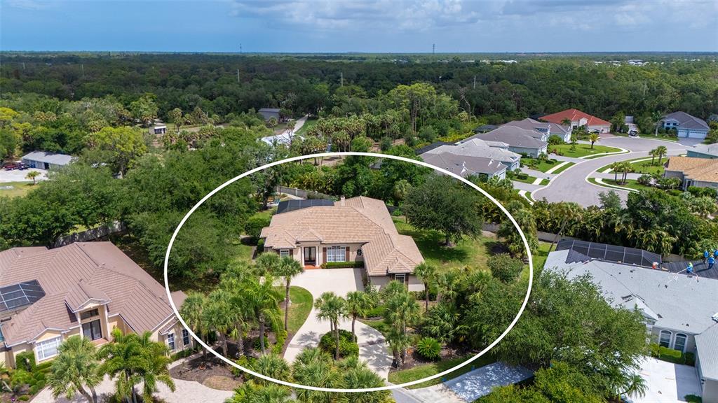 An aerial view shows a single-story house with a tan roof and circular driveway — 27 DOMINICA DRIVE, ENGLEWOOD, FL