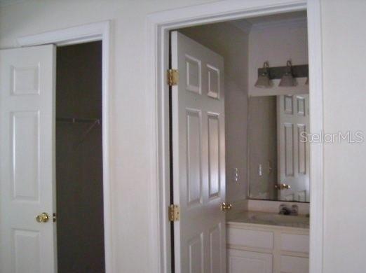 A view of a closet door and an open bathroom door with a vanity mirror — 2905 SW ARCHER ROAD UNIT T-5027, GAINESVILLE, FL