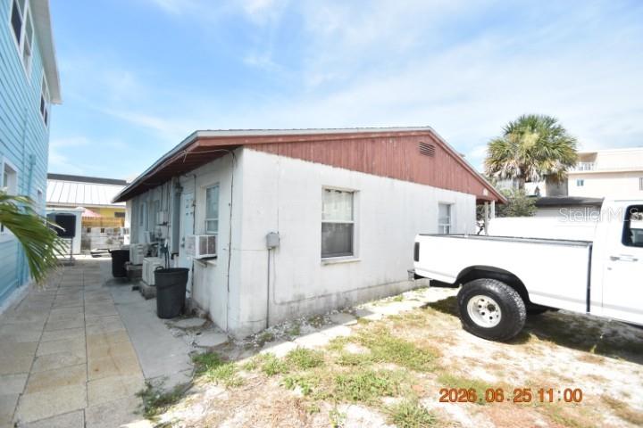 The exterior of a single-story building features white stucco walls and a brown wooden gable — 146 CORAL AVENUE UNIT C, ST PETERSBURG, FL