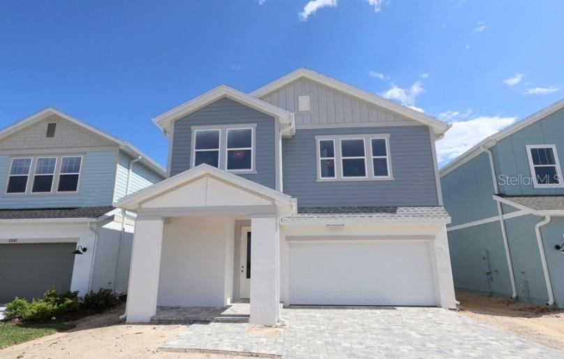 A two-story house with blue siding, a white garage, and a covered front entryway — 3395 YELLOW CASSIA DRIVE, WESLEY CHAPEL, FL