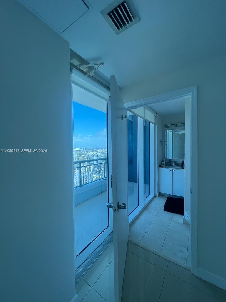 A view from a doorway looking toward a balcony and an adjacent bathroom — 60 SW 13th St # 2819, Miami FL 33130, MIAMI, FL