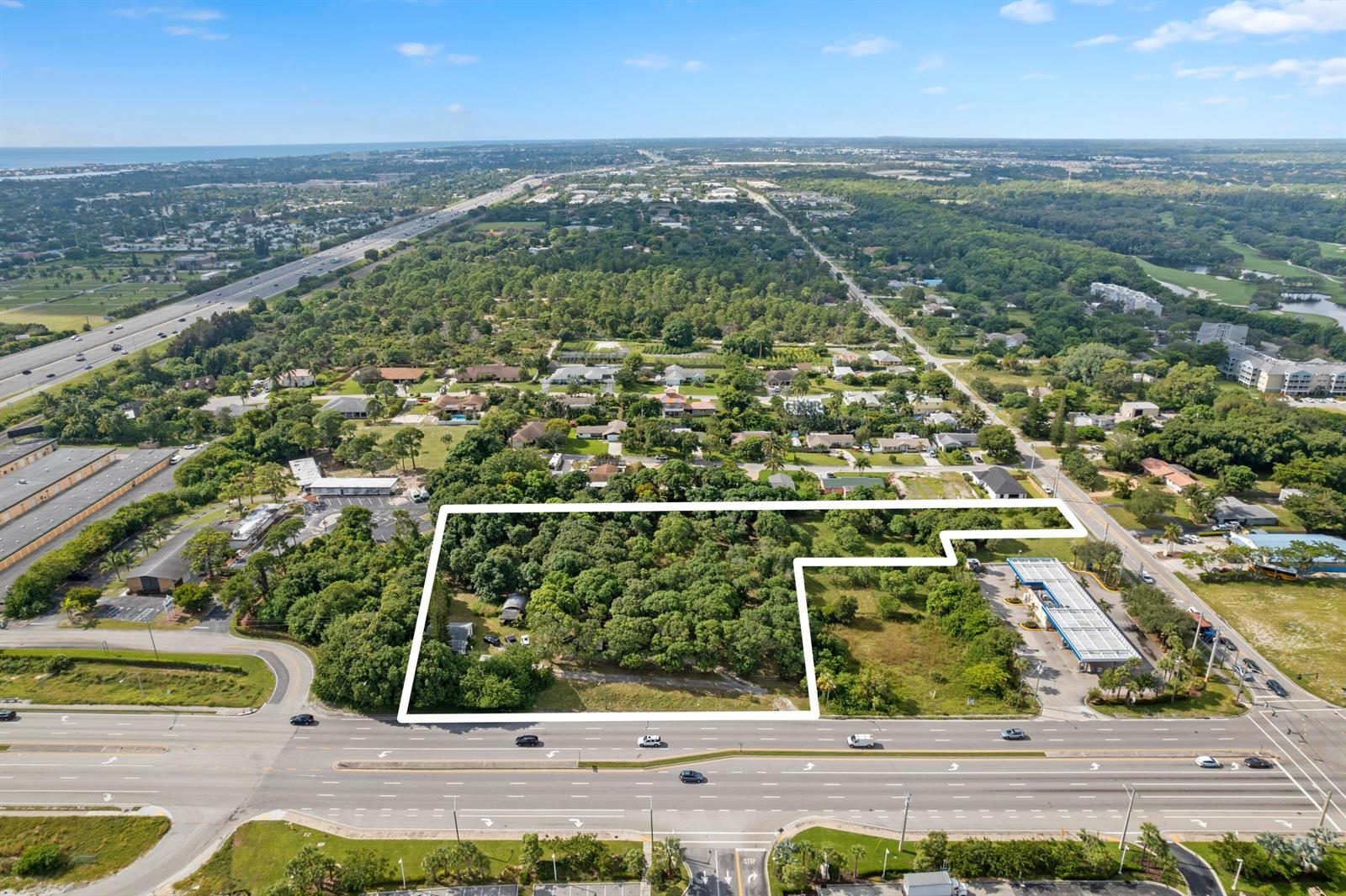 An aerial view shows a large, wooded plot of land outlined in white near a highway — 1908 Hypoluxo Road, Lake Worth FL 33462, LAKE WORTH, FL