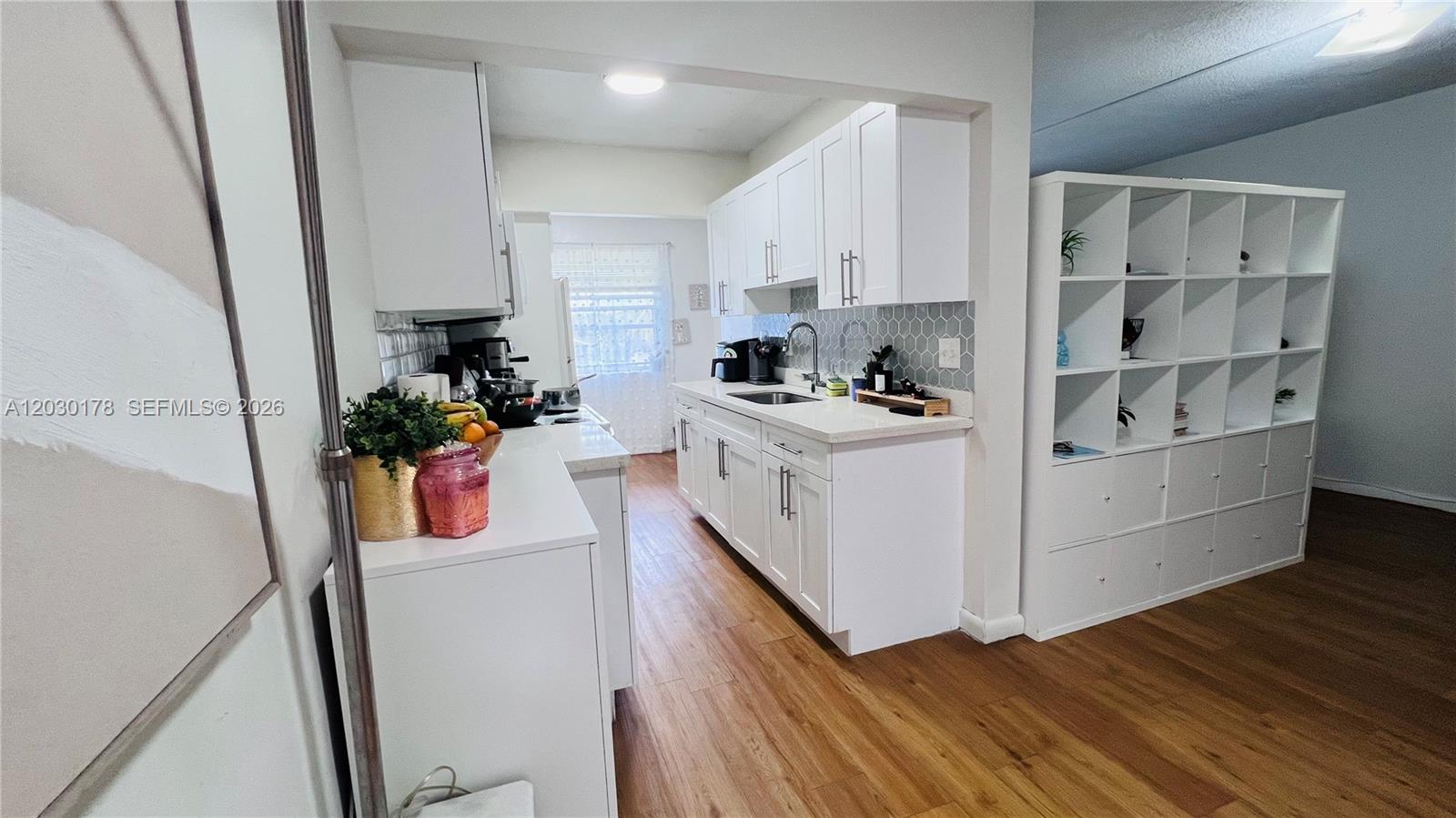 An empty room features wood-look flooring, white walls, and a textured accent wall — 1100 NE 1st Ct # 213, Hallandale Beach FL 33009, HALLANDALE BEACH, FL