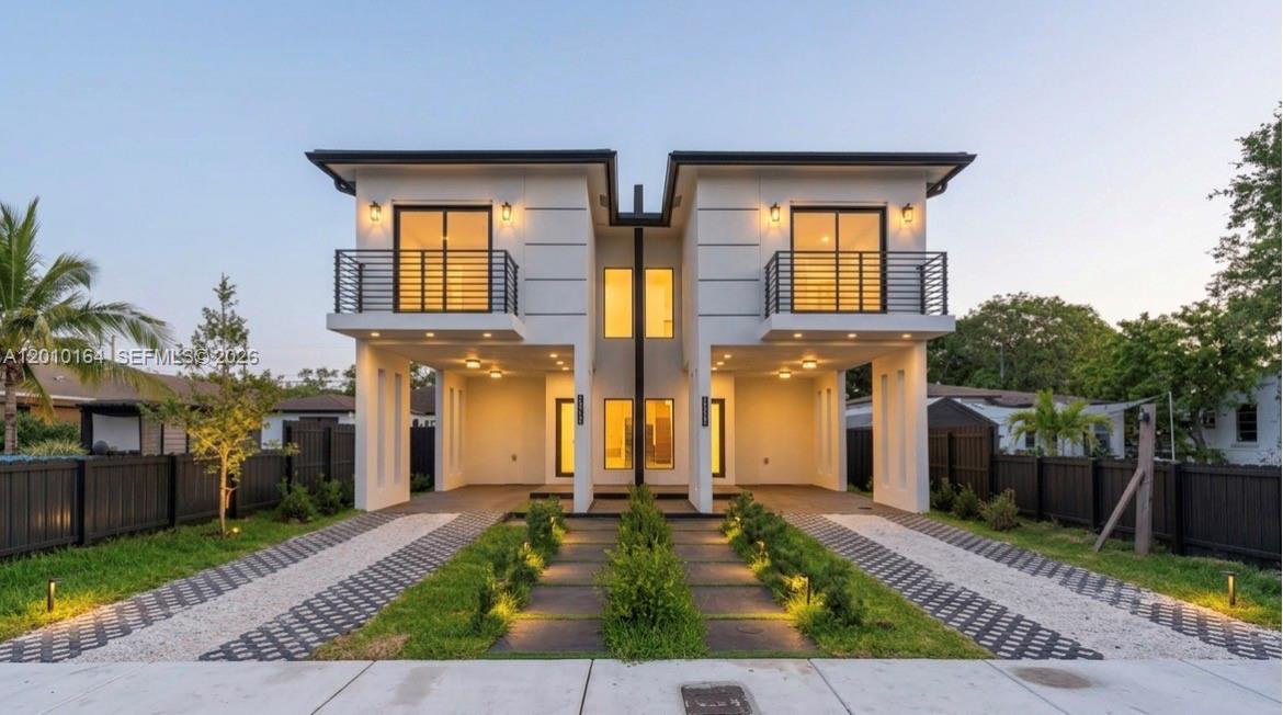 A modern two-story duplex with white exterior walls, balconies, and covered ground-level parking — 1816 NW 49th St, Miami FL 33142, MIAMI, FL