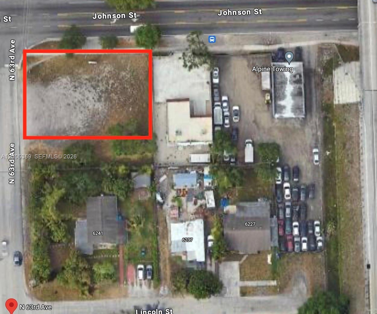 An aerial view shows a vacant rectangular lot outlined in red next to a commercial property — N 63rd Ave, Hollywood FL 33024, HOLLYWOOD, FL