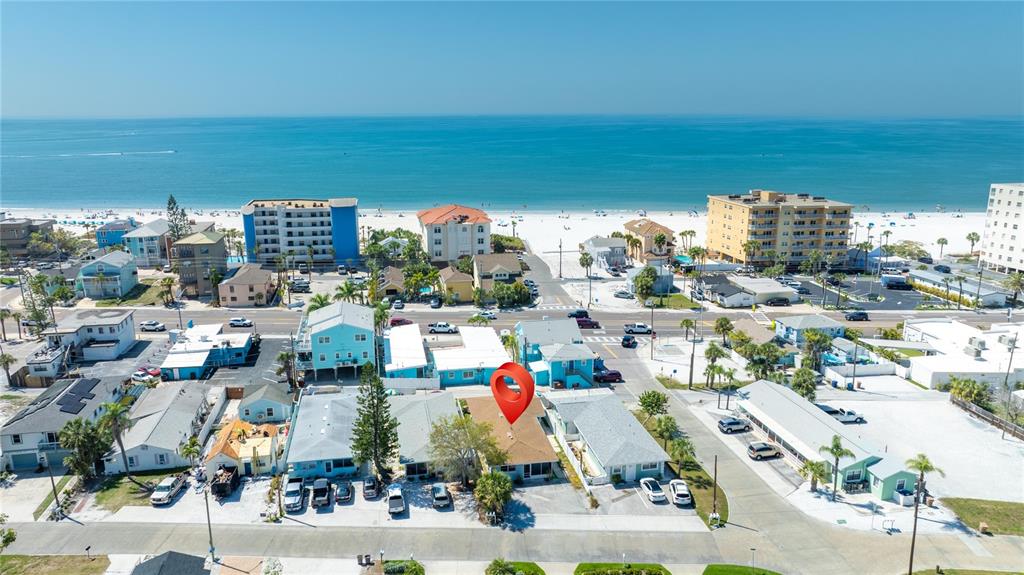 An aerial view shows a beachside neighborhood with a red location pin on a house — 13388 1ST STREET E, MADEIRA BEACH, FL