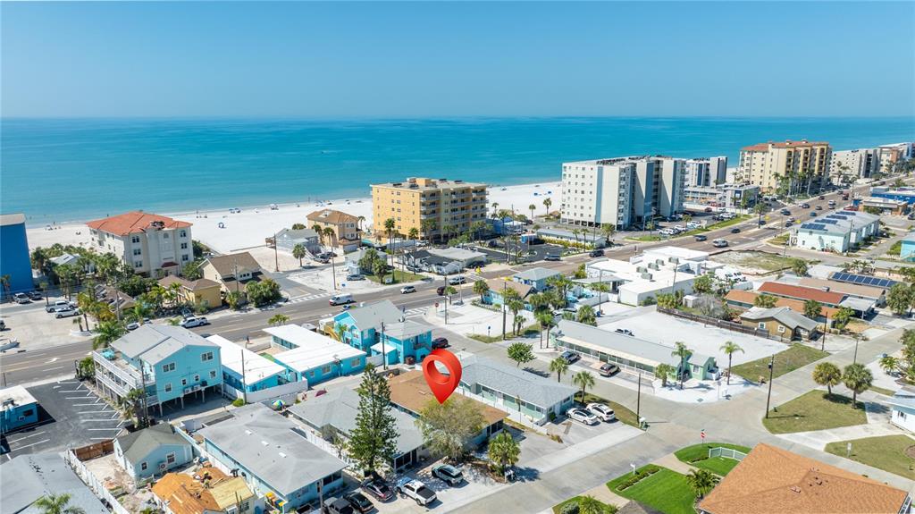 An aerial view shows a coastal neighborhood with a red location pin over a building — 13388 1ST STREET E, MADEIRA BEACH, FL