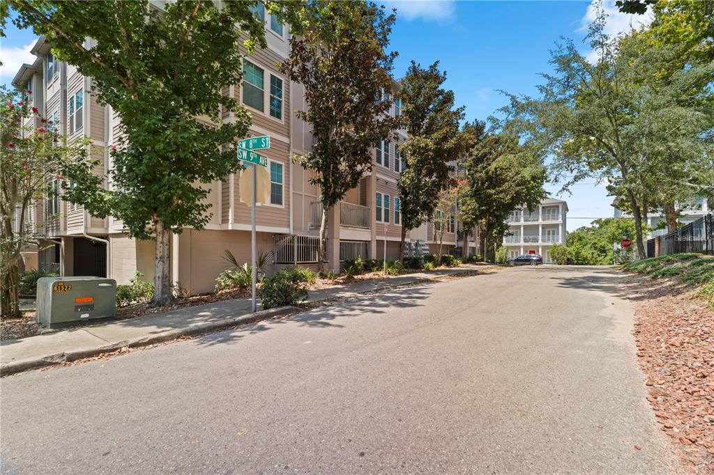 A multi-story apartment building stands at the corner of a street with mature trees — 835 SW 9TH STREET UNIT 101, GAINESVILLE, FL