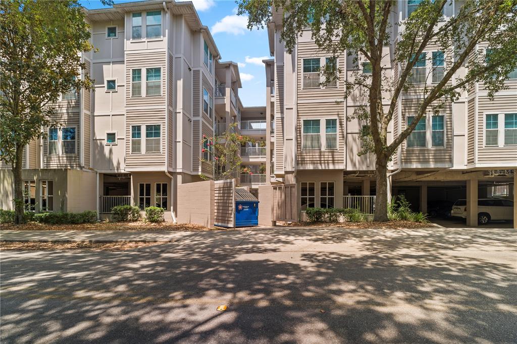 Exterior view of a multi-story apartment building with a blue dumpster in the center — 835 SW 9TH STREET UNIT 101, GAINESVILLE, FL