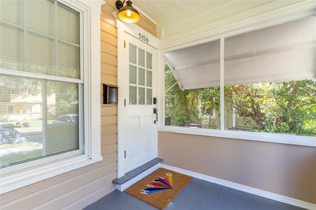 A covered front porch features a white door with glass panes and a welcome mat — 515.5 DANIELS AVENUE, ORLANDO, FL