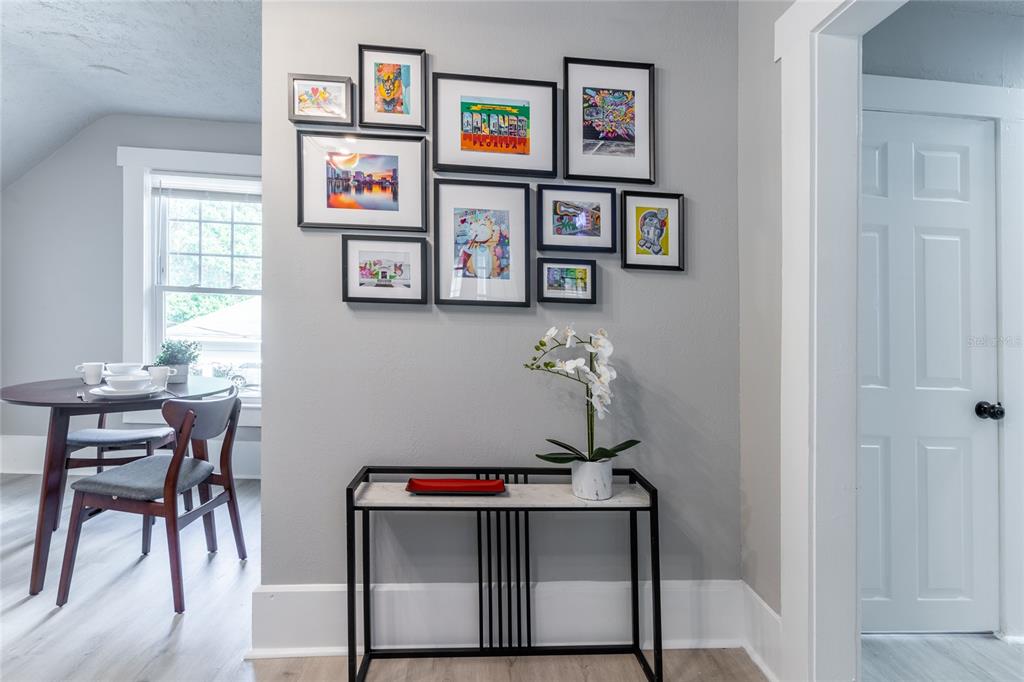 A dining area features a gallery wall above a console table with a potted orchid — 515.5 DANIELS AVENUE, ORLANDO, FL