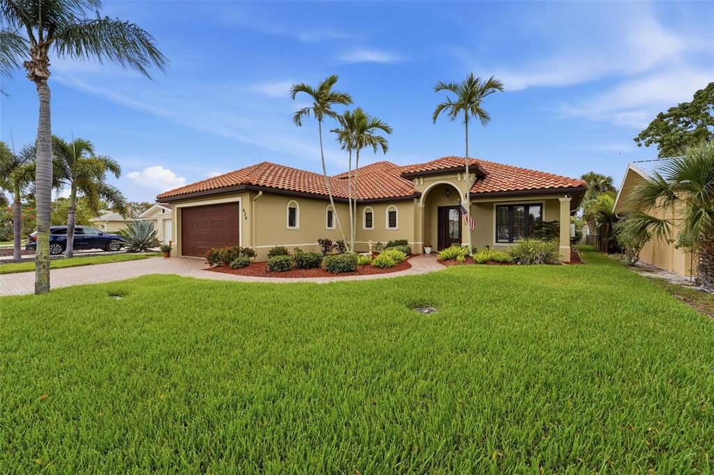 A single-story house with a tile roof, tan stucco exterior, and a front lawn — 424 PENSACOLA ROAD, VENICE, FL