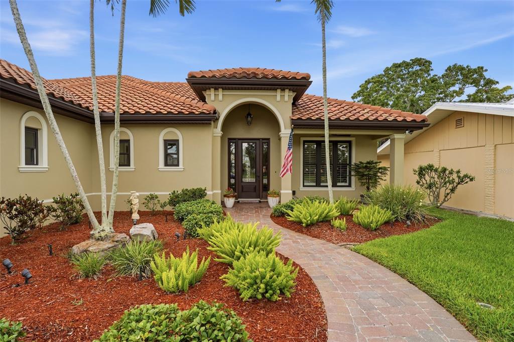 A single-story house with a tiled roof, arched entryway, and a brick walkway — 424 PENSACOLA ROAD, VENICE, FL