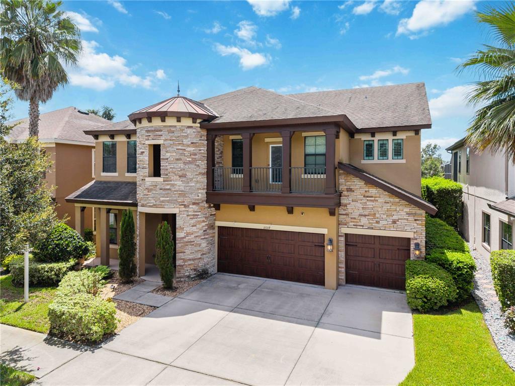 A two-story house with a stone turret, a balcony, and a three-car garage — 11009 CHARMWOOD DRIVE, RIVERVIEW, FL