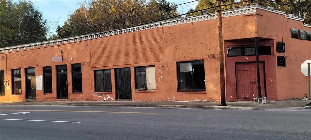 A single-story, orange-painted brick commercial building sits along a paved road — 24422 W US 27 HIGHWAY, HIGH SPRINGS, FL