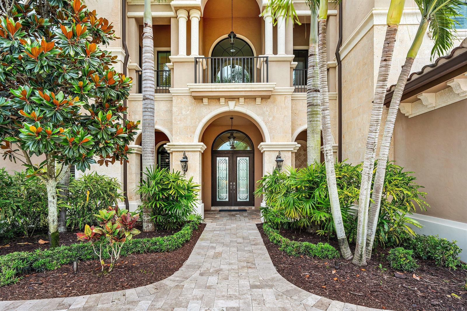 A stone walkway leads to the arched entryway of a multi-story Mediterranean-style home — 9616 Moritz Way, Delray Beach FL 33446, DELRAY BEACH, FL