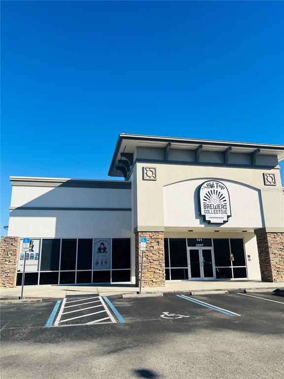 A commercial building exterior features a stone facade, large glass windows, and a brewery sign — 2507 LAKEWOOD RANCH BOULEVARD, BRADENTON, FL