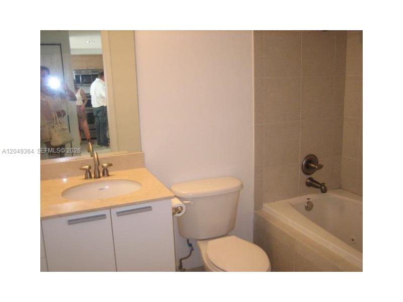 A bathroom features a vanity with a beige countertop, a toilet, and a tiled tub — 140 S DIXIE HY # 502, Hollywood FL 33020, HOLLYWOOD, FL