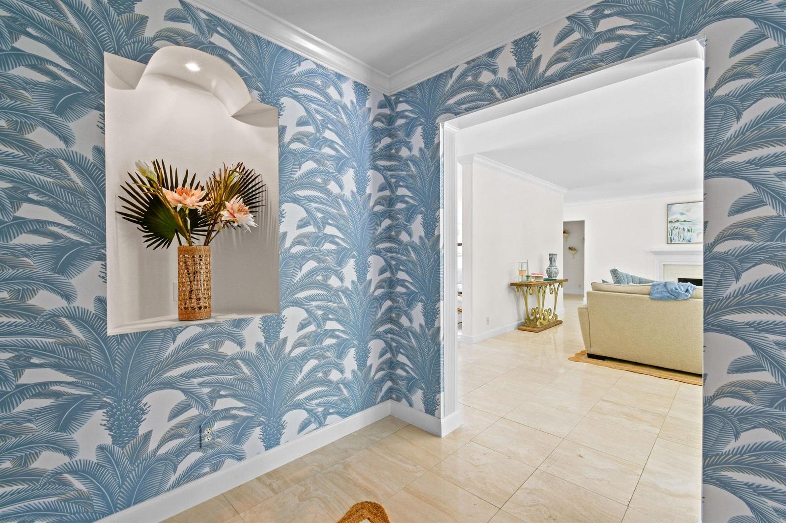 An entryway features blue palm-patterned wallpaper, a recessed wall niche, and light-colored tile flooring — 117 Via Vizcaya, Palm Beach FL 33480, PALM BEACH, FL