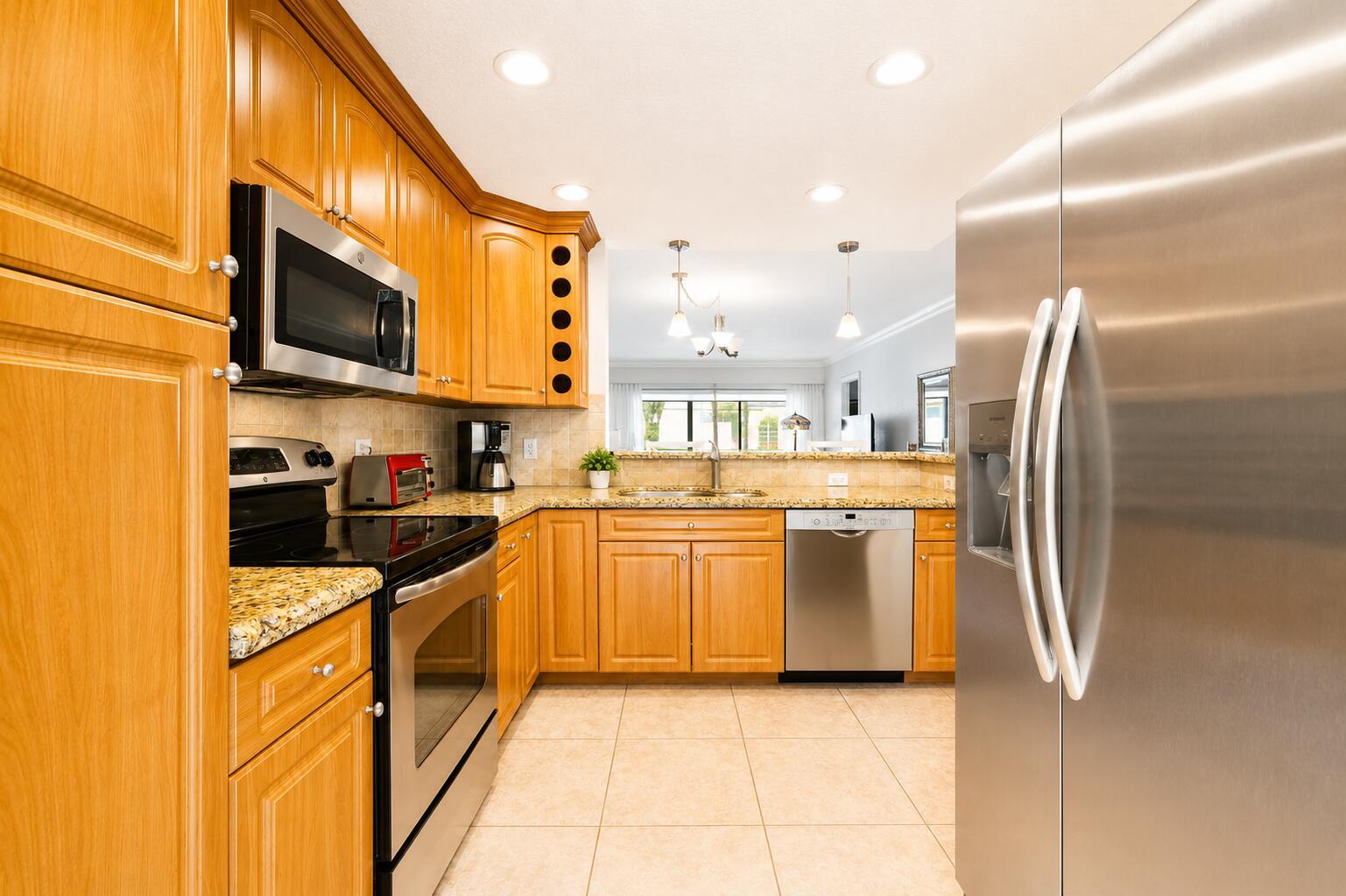 A kitchen with light wood cabinets, stainless steel appliances, and granite countertops — 1501 S Ocean Boulevard # 123, Pompano Beach FL 33062, POMPANO BEACH, FL