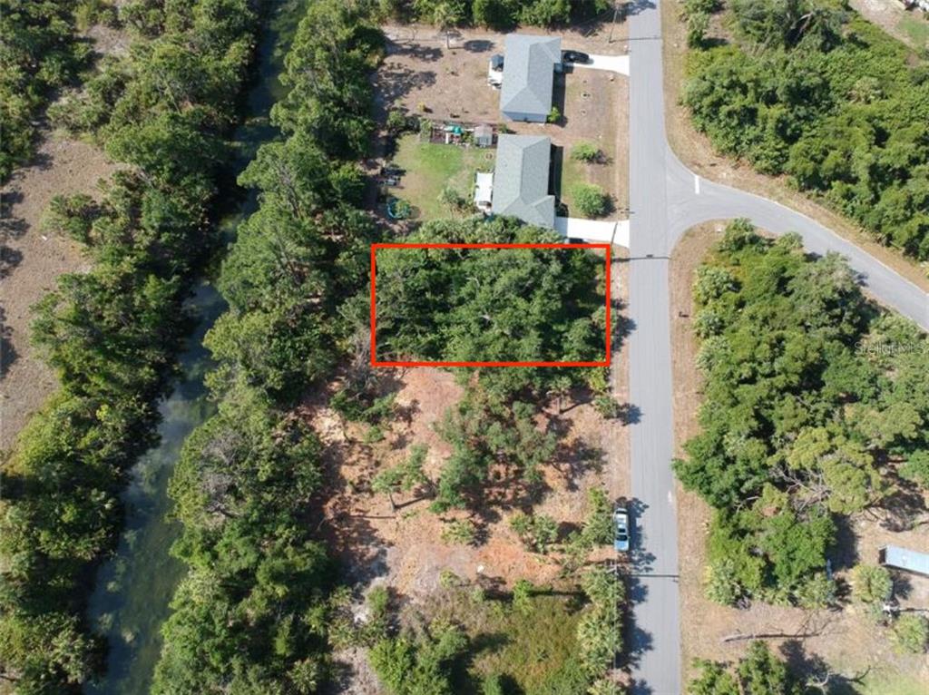 An aerial view shows a rectangular lot outlined in red next to a paved road — 242 LONGLEY DRIVE, PORT CHARLOTTE, FL