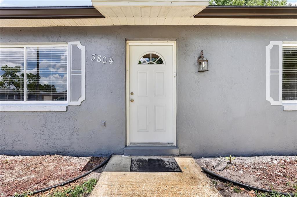 The exterior of a gray house features a white front door and two windows — 3804 JANIE COURT, ORLANDO, FL