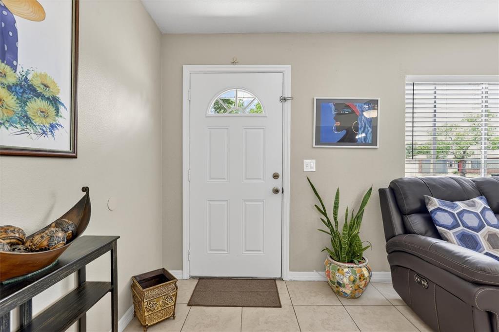 A living room entryway features a white front door, tile flooring, and a potted plant — 3804 JANIE COURT, ORLANDO, FL