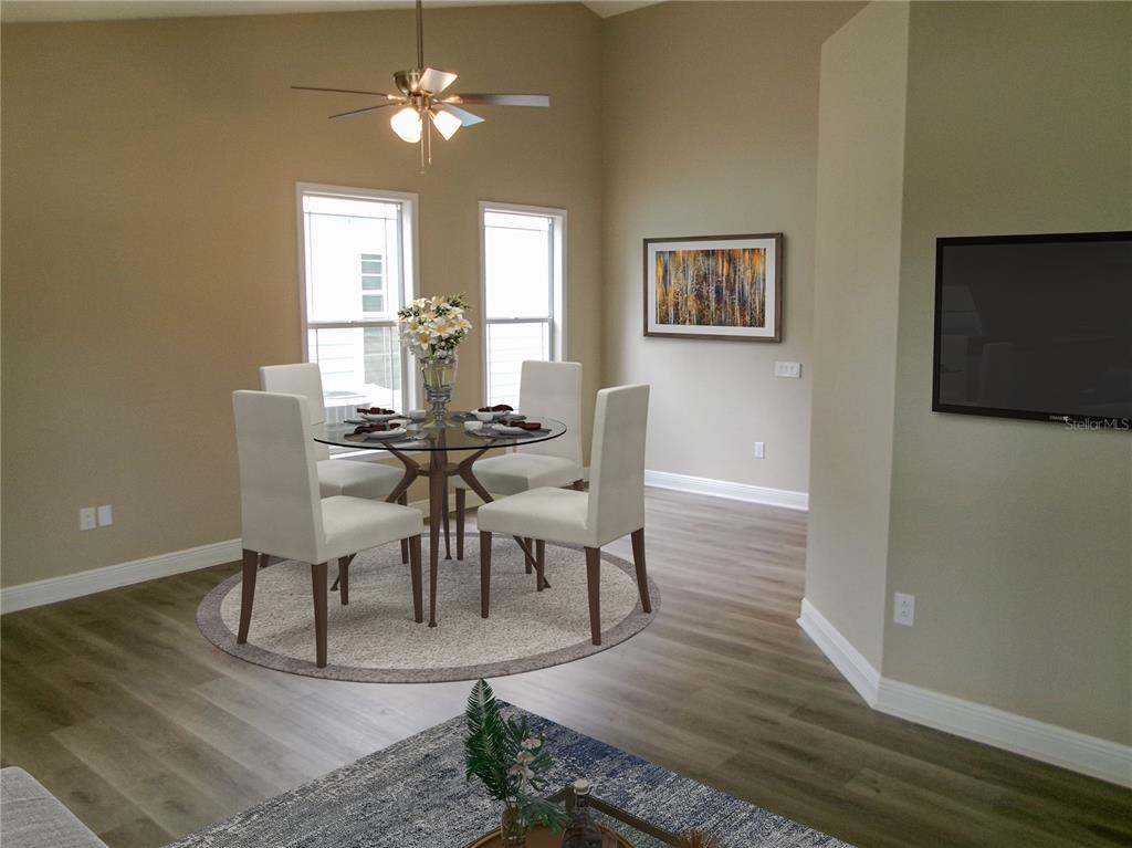 This dining area features a glass table, four white chairs, and a ceiling fan — 37450 PICKETTS MILL AVENUE, ZEPHYRHILLS, FL