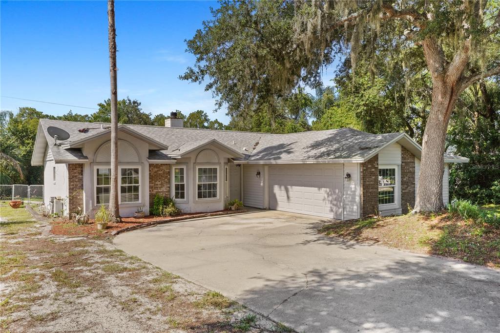 A single-story house with a brick and stucco exterior, a two-car garage, and a driveway — 515 CLOUDCROFT DRIVE, DELTONA, FL