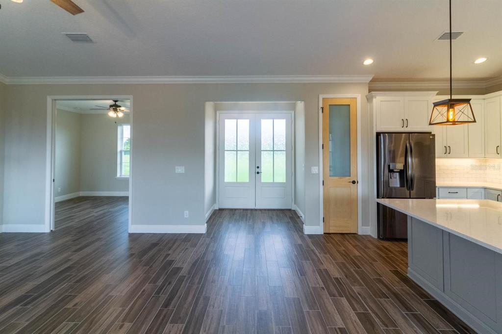 A kitchen and entryway area featuring wood-look tile flooring, white cabinets, and a glass-paneled door — TBD LOT 1 BENTLEY ROAD, LEESBURG, FL