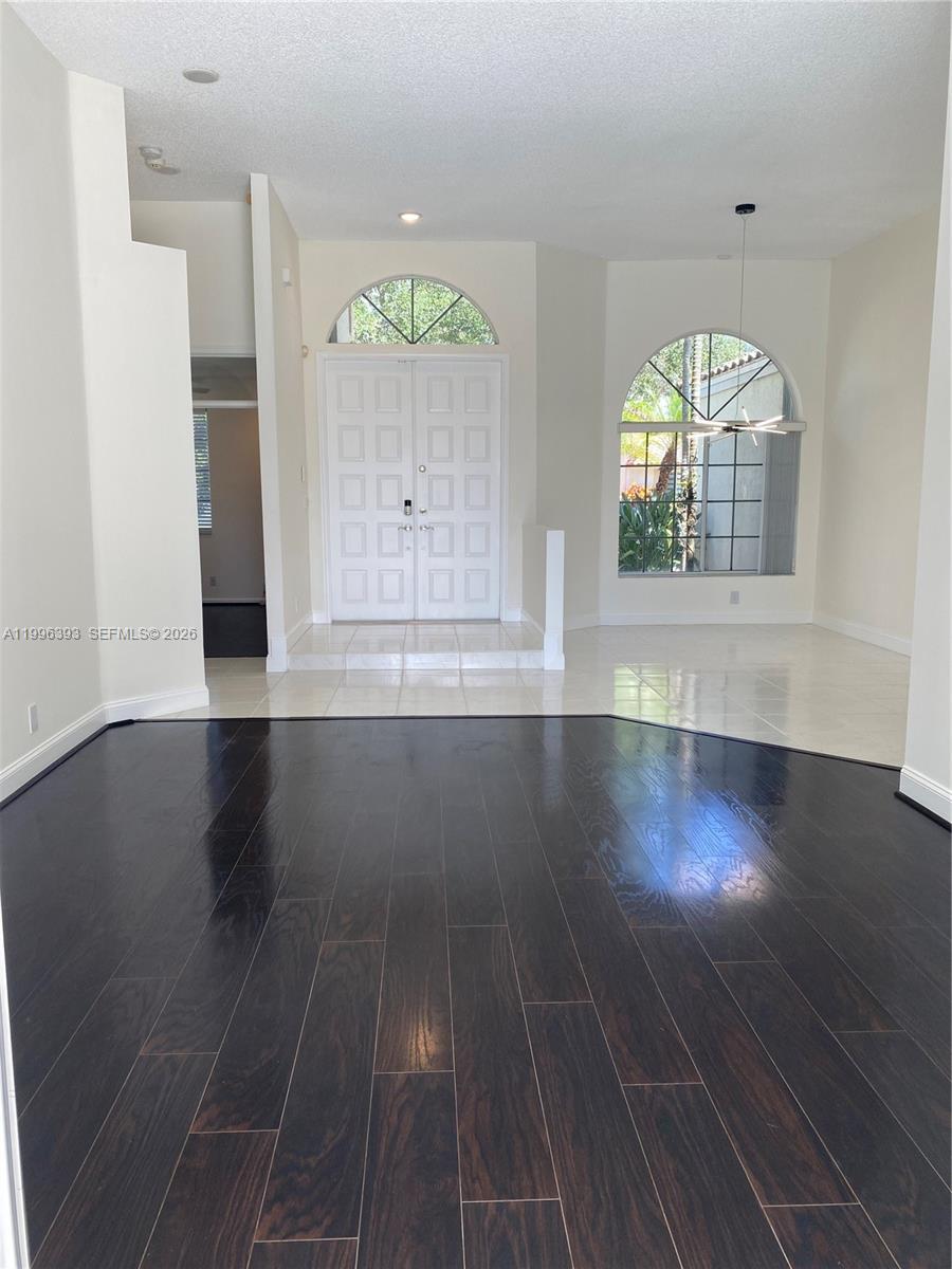 An entryway features dark hardwood floors, a tiled foyer, and a double front door — 3066 Lakewood Cir # 3066, Weston FL 33332, WESTON, FL