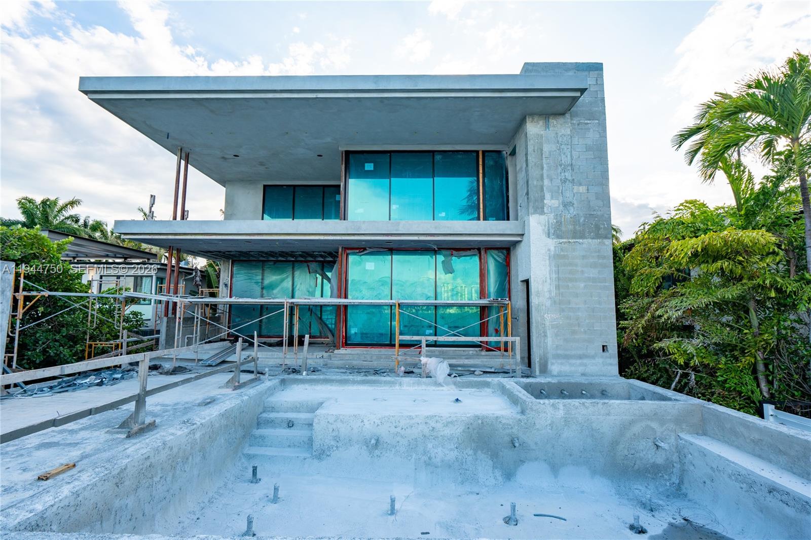 A modern two-story house under construction features large glass windows and an unfinished concrete pool — 333 E Rivo Alto Dr, Miami Beach FL 33139, MIAMI BEACH, FL