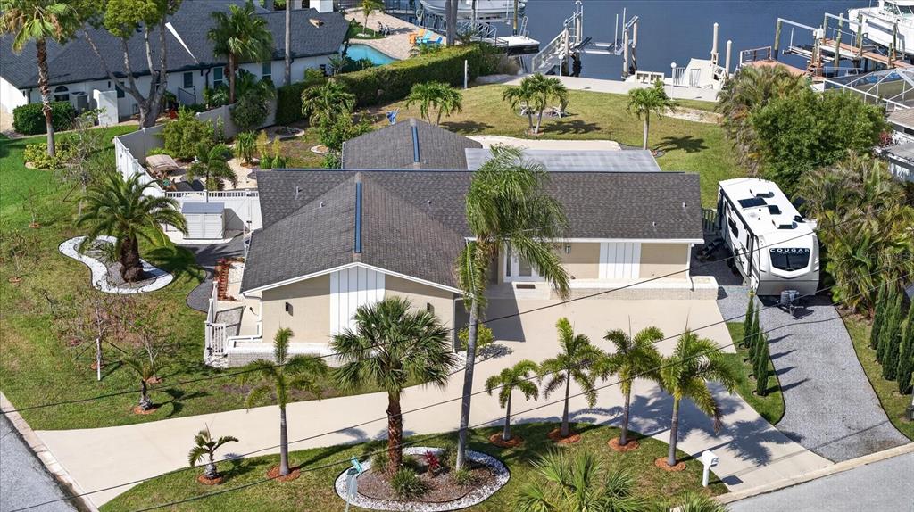 An aerial view shows a single-story house with a driveway, palm trees, and a camper — 3619 CORSAIR COURT, NEW PORT RICHEY, FL