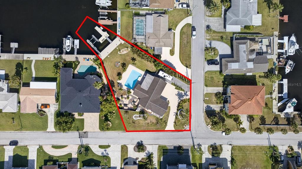 An aerial view of a waterfront residential property with a pool, dock, and driveway — 3619 CORSAIR COURT, NEW PORT RICHEY, FL