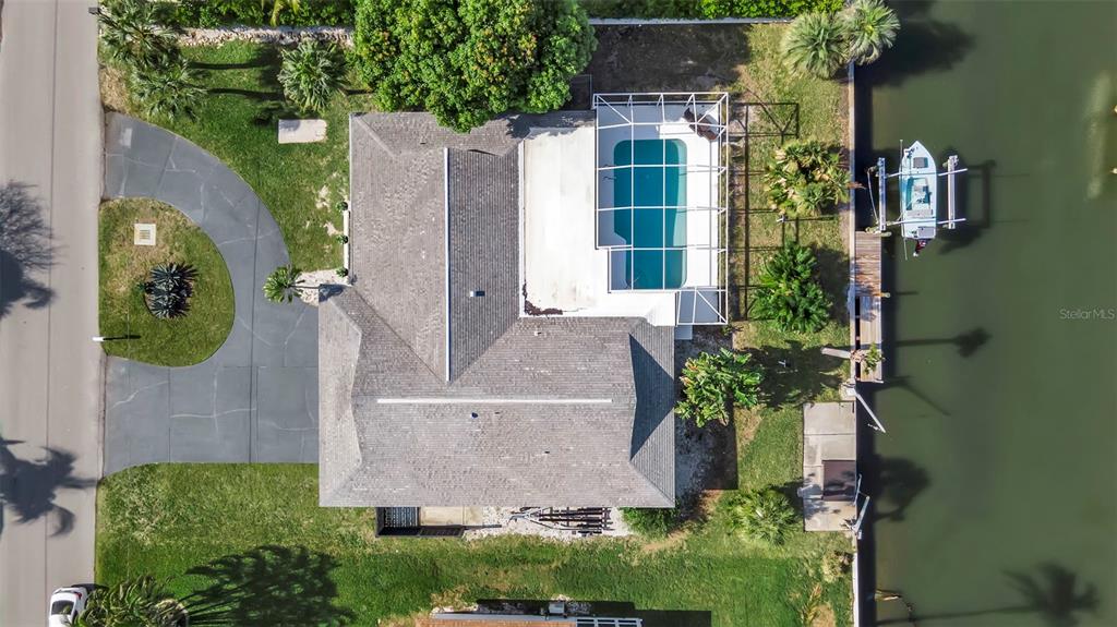 An aerial view shows a house with a pool cage, driveway, and boat dock — 1649 STANFORD LANE, SARASOTA, FL