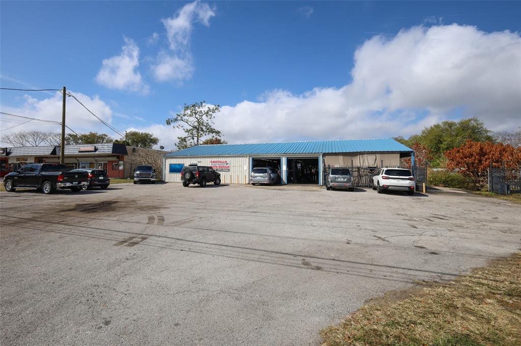 An exterior view of a single-story auto repair shop with a blue metal roof — 4070 S GOLDENROD ROAD, ORLANDO, FL