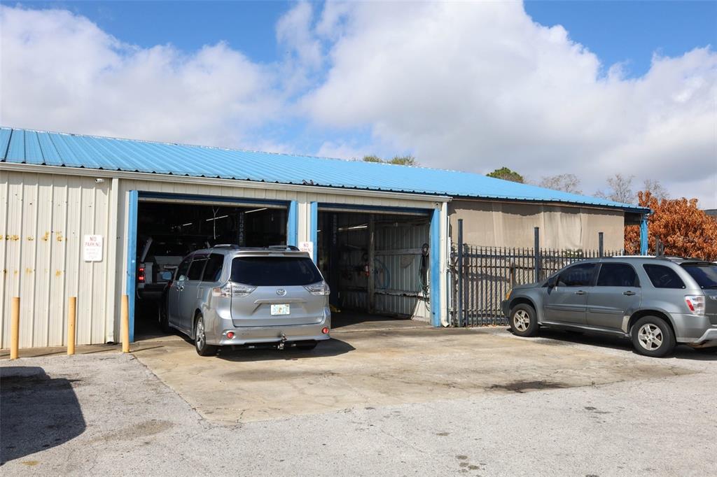 A commercial garage building with two open bays and two parked vehicles outside — 4070 S GOLDENROD ROAD, ORLANDO, FL