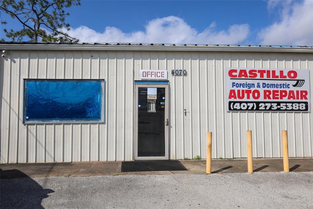 The exterior of a metal-sided commercial building features an office entrance and auto repair signage — 4070 S GOLDENROD ROAD, ORLANDO, FL