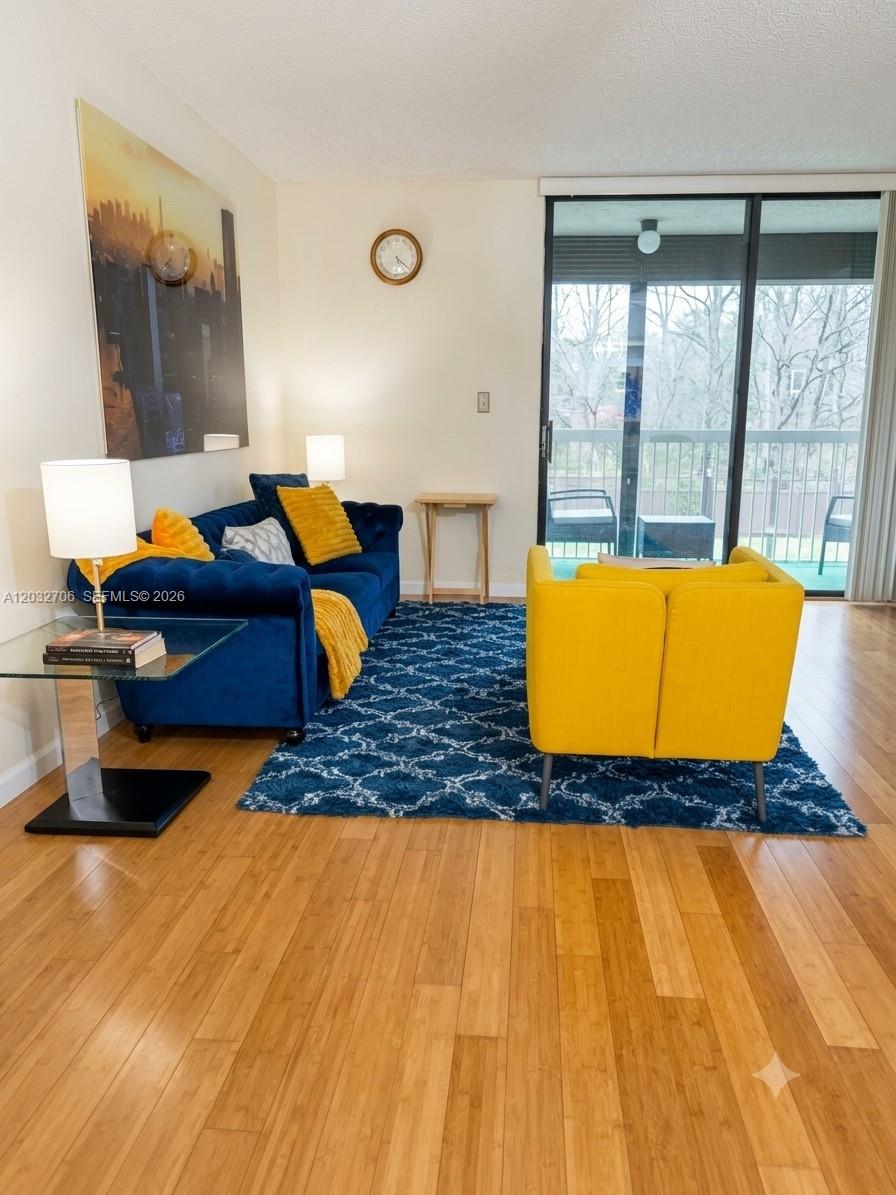 A living room features a blue sofa, a yellow armchair, and a blue patterned rug — 5570 NW 44th St # 308A, Lauderhill FL 33319, LAUDERHILL, FL