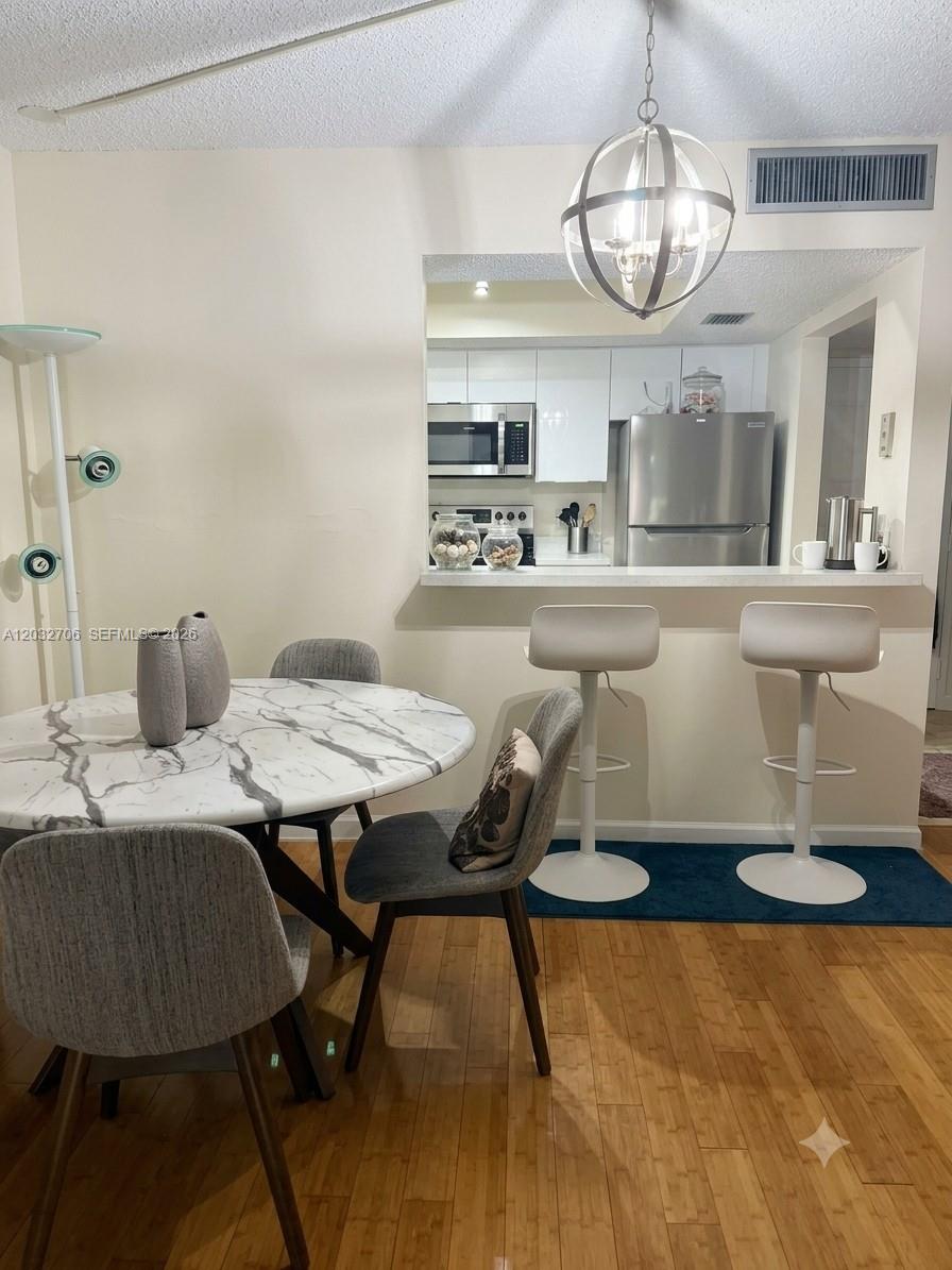 A dining area features a marble-topped table and a breakfast bar with two stools — 5570 NW 44th St # 308A, Lauderhill FL 33319, LAUDERHILL, FL