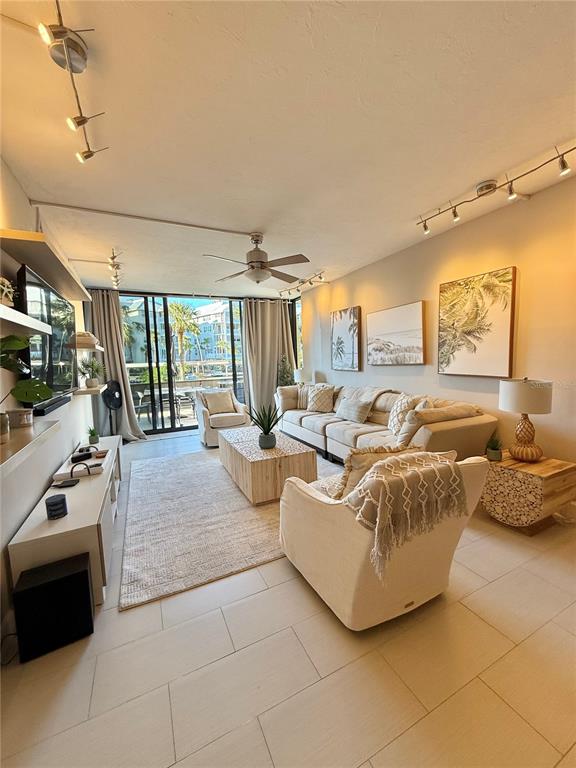 A living room features a sectional sofa, an armchair, a coffee table, and large windows — 5855 MIDNIGHT PASS ROAD UNIT 108, SARASOTA, FL