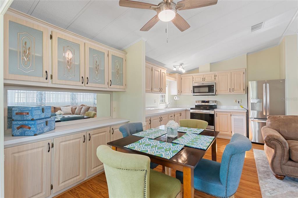 A dining area with a wooden table, four chairs, and light wood kitchen cabinetry — 16 CHAMPIONSHIP DR, DAVENPORT, FL