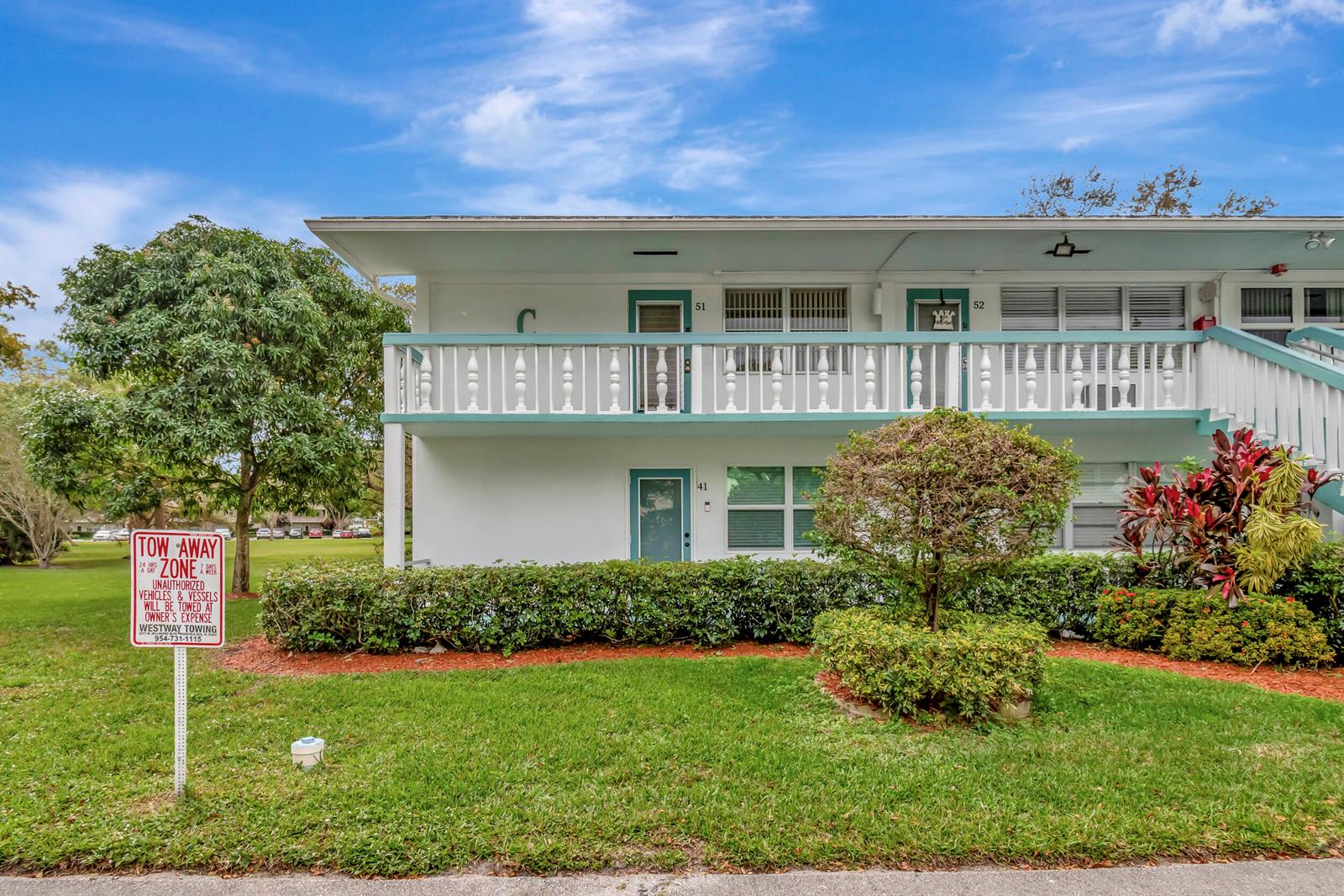 A two-story apartment building features white exterior walls, teal trim, and a second-floor balcony — 51 Ventnor C, Deerfield Beach FL 33442, DEERFIELD BEACH, FL