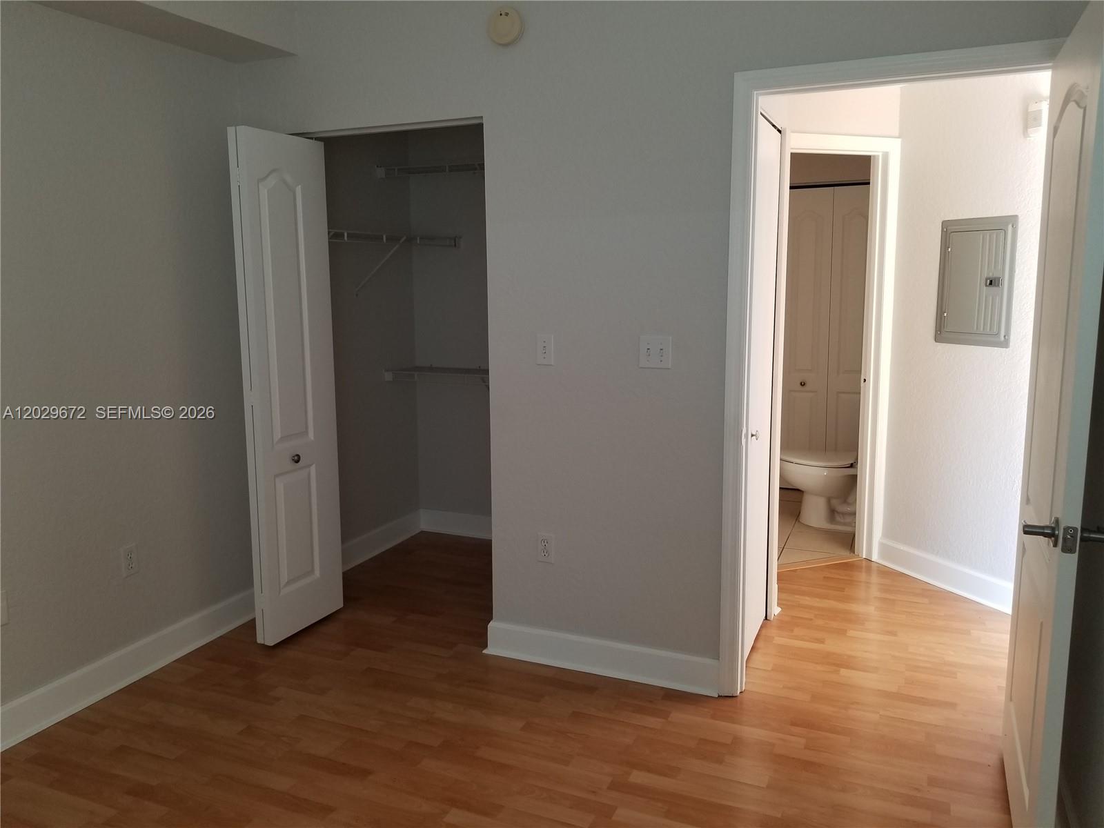 A bedroom features light wood flooring, a walk-in closet, and an attached bathroom — 6001 SW 70th St # 538, South Miami FL 33143, SOUTH MIAMI, FL