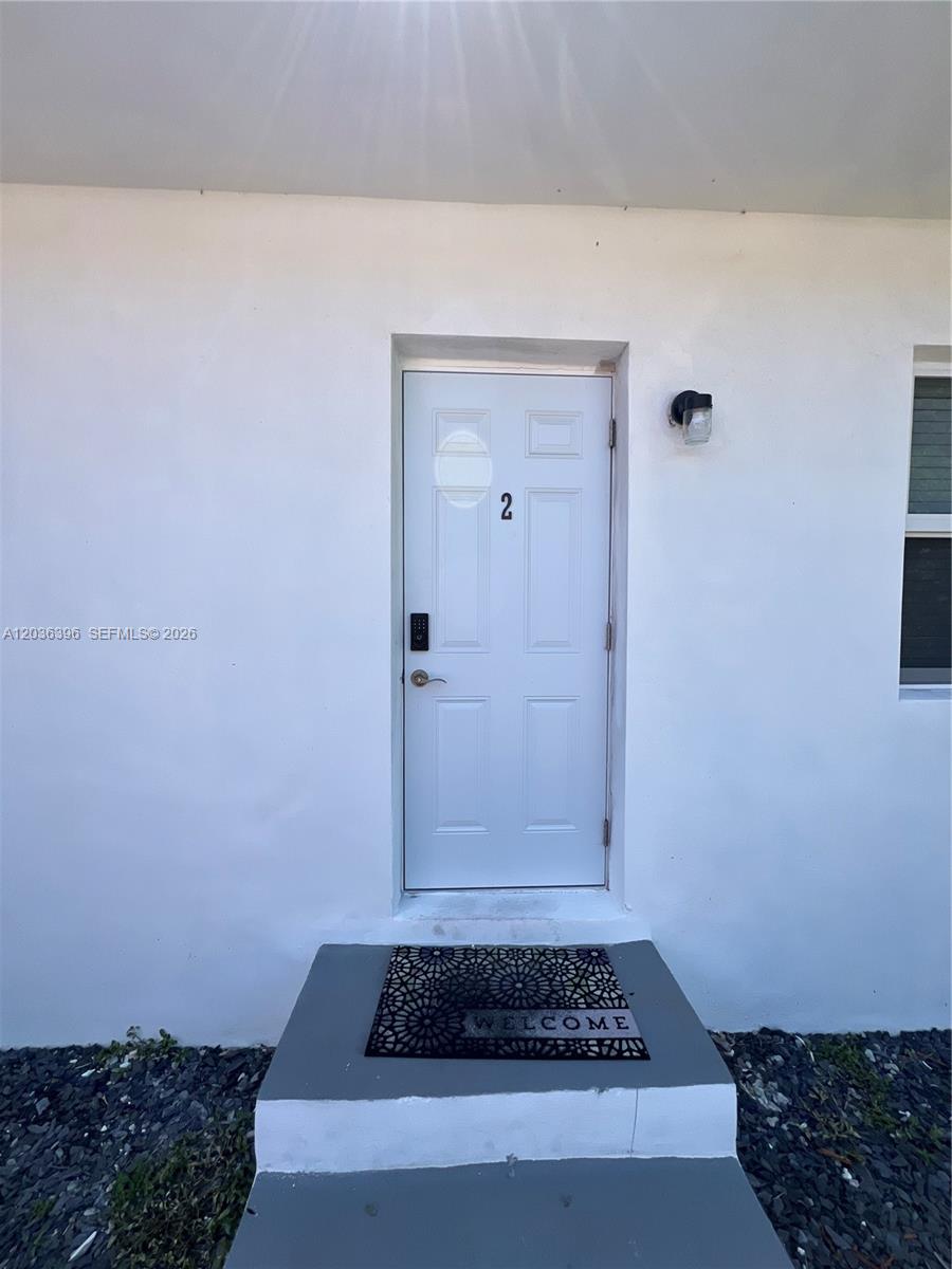 A white exterior door marked with the number two sits above a welcome mat — 2847 Polk St # 2, Hollywood FL 33020, HOLLYWOOD, FL