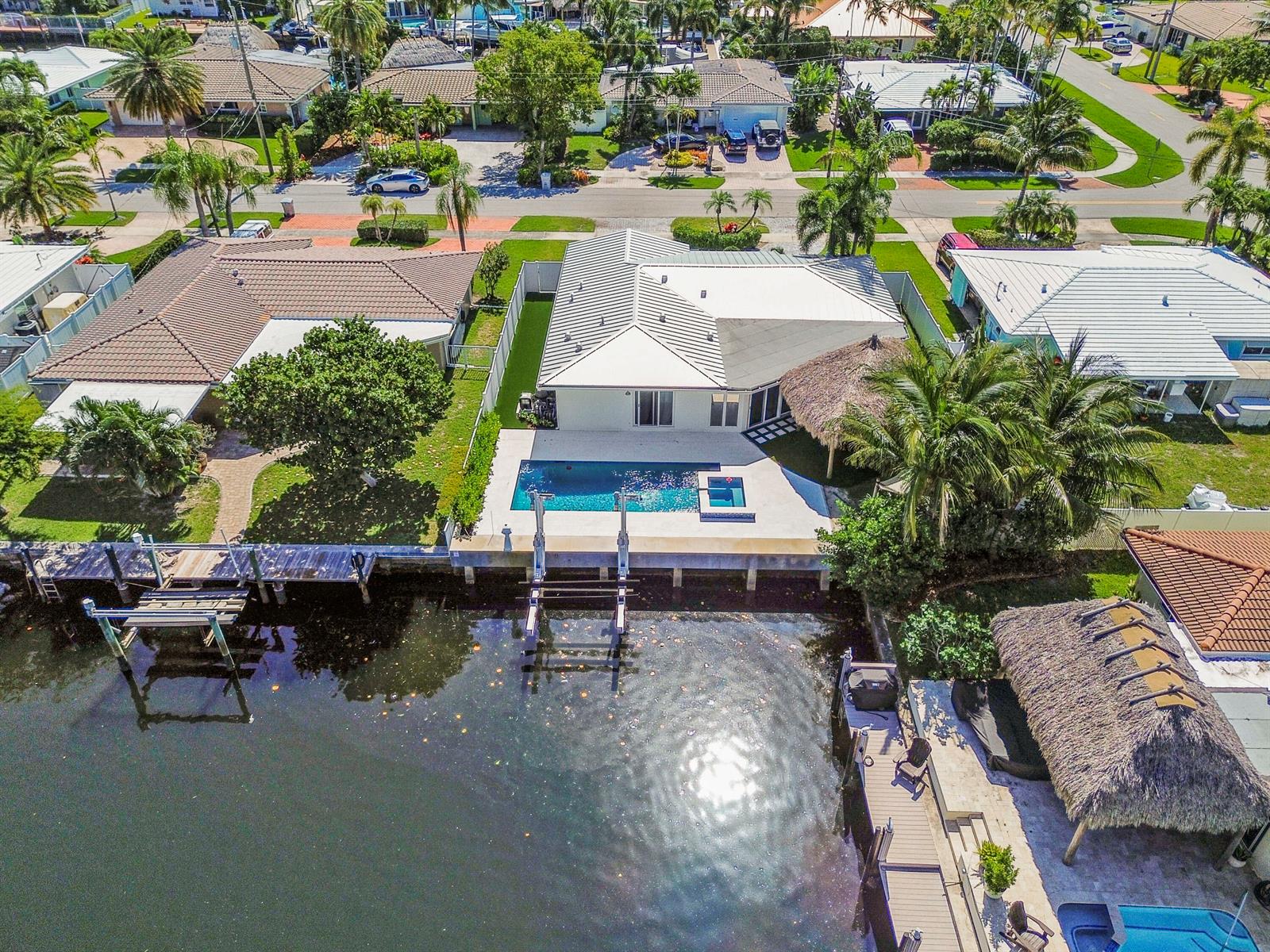 An aerial view shows a waterfront house with a pool, boat lift, and thatched gazebo — 511 SE 9th Avenue, Pompano Beach FL 33060, POMPANO BEACH, FL