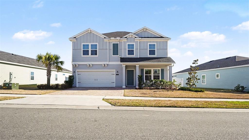 A two-story, light blue suburban house with a two-car garage and a paved driveway — 1795 NW 44TH COURT ROAD, OCALA, FL