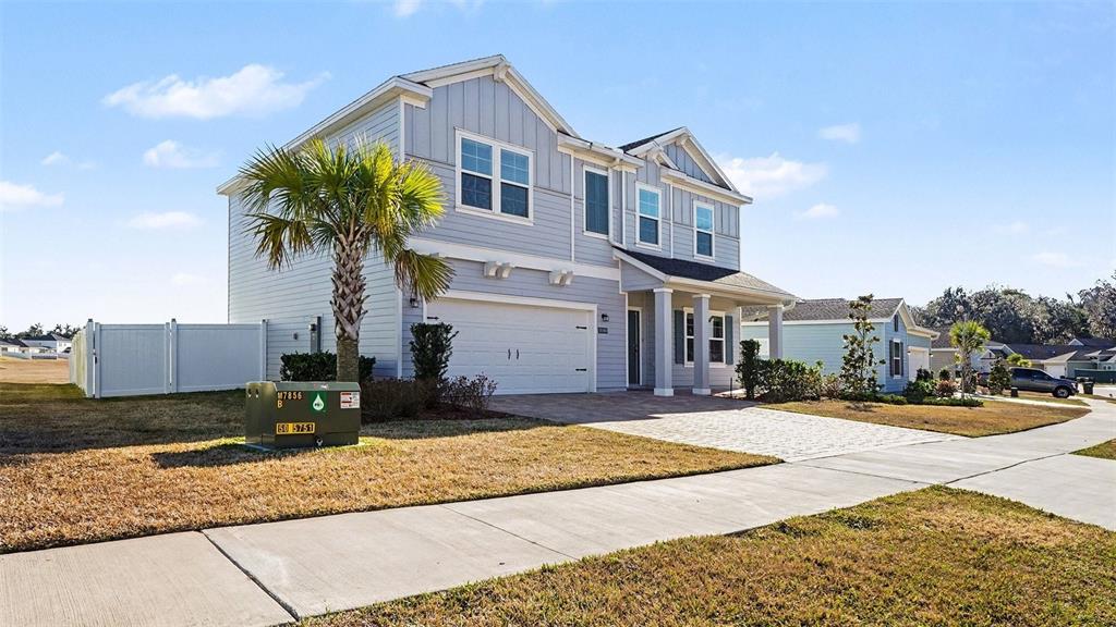 A two-story light blue house with a two-car garage and a paved driveway — 1795 NW 44TH COURT ROAD, OCALA, FL
